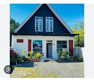 a house with a black and white at Casa Tripa Homestay in Meulaboh