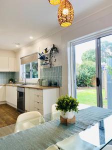 a kitchen with a glass table with chairs and a window at GREENVIEW, BFast,WiFi,Fetch, Walk2Pizza,Liquor in Bell Post Hill