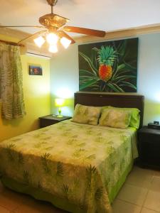 a bedroom with a bed with a pineapple painting on the wall at Garden condos, unit#8 in Sosúa +16 photos