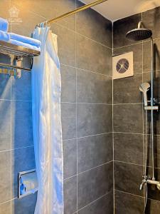 a shower with a blue shower curtain in a bathroom at KunKin Luxury Hotel & Apartment in Ho Chi Minh City +66 photos