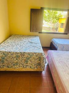 zwei Betten in einem Zimmer mit Fenster in der Unterkunft Sítio do Ademir in Jaboticatubas + 20 Fotos