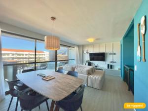 a dining room and living room with a table and a couch at Condomínio Mediterranee Residence por Be My Guest in Aquiraz