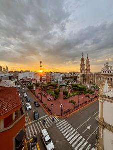 a city street with a sunset in the background at Hotel Plaza in Tepatitlán de Morelos