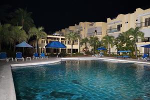a swimming pool in front of a hotel at night at Garden condos, unit#8 in Sosúa