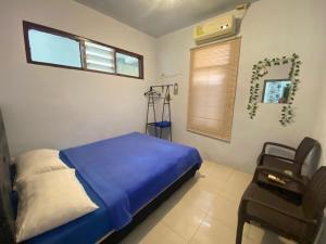 a bedroom with a bed and a chair in it at Neo Robiu & Ijen Tour in Banyuwangi