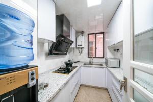 上海市にあるShanghai Fatty Homestay - Jiafa Building near West Nanjing Road subway and People Squareの白いキャビネットと大きな窓のあるキッチン +10枚の写真
