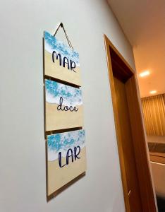 FLAT DE LUXO vista piscinas, Praia de Muro Alto - Malia Beach في إيبوجوكا: لوحة معلقة على جدار بجوار باب