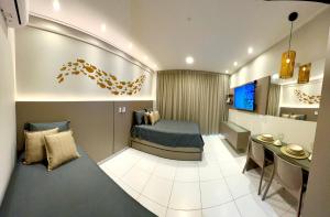 a room with a bed and a television in it at Flat 400m da Praia de Muro Alto - 302C Malia Beach in Ipojuca