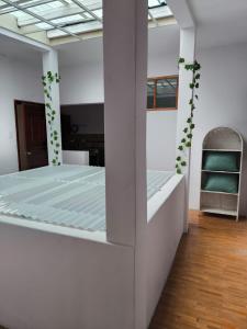 a white room with a bed in it with a chair at Departamento Familiar La Merced Terracota in Riobamba