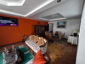 a living room with couches and a table and a television at Departamento Familiar La Merced Terracota in Riobamba