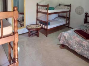 a room with bunk beds and a chair and a mirror at Hostel e Pousada Araquari in Paraty