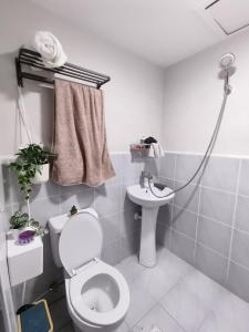 a bathroom with a toilet and a sink at Studio w pool & balcony, city & mountain view Mactan airport in Suba