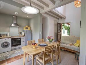 a kitchen and dining room with a table and chairs at Maison cosy avec terrasse, jardin fleuri, et tout confort à Saint-Galmier - FR-1-496-292 in Saint-Galmier