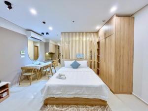 a bedroom with a large bed and a table at The Sóng Condotel Hao's Homestay in Vung Tau