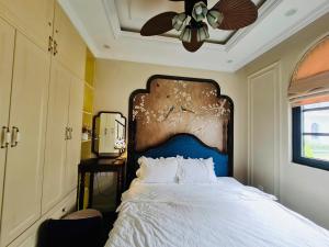 a bedroom with a bed with a ceiling fan at Dragon Villa 3 Bedroom - Sonasea Vân Đồn Harbor City in Thâm Câu +51 photos