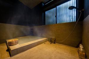 a bathroom with a bath tub with a shower at Okamotoya in Beppu