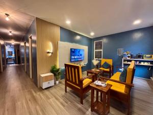 a living room with a couch and chairs and a table at Balai Evelyn Homestay in Coron