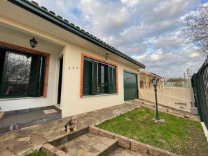 a dog sitting in front of a house at Suite em casa familiar in São Gabriel