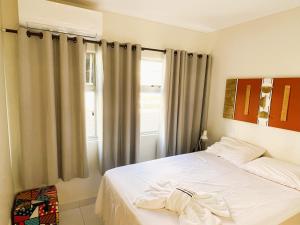 una camera da letto con un letto bianco e una finestra di Hospede-se com conforto no Setor Sudoeste a Brasilia