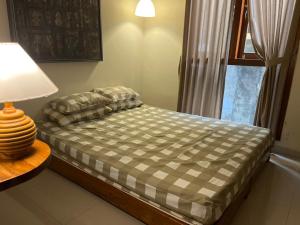 a bedroom with a bed with a lamp and a window at Mawartiga Homestay in Demangan +6 photos