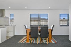 a dining room with a wooden table and chairs at Huka Falls Getaway (Family escape) in Taupo +3 photos