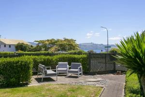 un groupe de chaises assises sur une terrasse dans l'établissement You little beauty - Wharewaka Beach Magic, à Taupo
