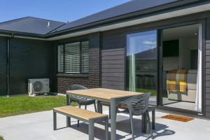 einen Tisch und Stühle auf der Terrasse eines Hauses in der Unterkunft Sophistication Meets Relaxation in Taupo