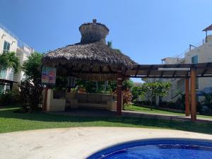 a hut with a swimming pool next to a swimming pool at Marina Diamante Victory in Acapulco
