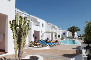 a group of people laying on chaise lounges at a hotel at Cactus in Puerto del Carmen