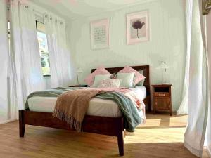 a bedroom with a bed with pink and green pillows at Heavenly Views in Airlie Beach +11 photos