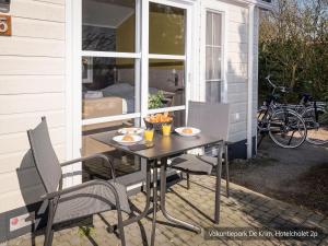 una mesa y sillas en el porche de una casa en Texel Chalet w Hotel Comfort, en De Cocksdorp