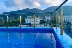 a swimming pool with a view of buildings and mountains at Marina Bay Con Dao Hotel in Con Dao