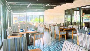 ein Restaurant mit Holztischen und -stühlen und Fenstern in der Unterkunft Marina Bay Con Dao Hotel in Con Dao