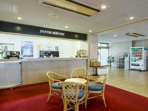 a restaurant with a table and chairs and a counter at ホテル亀山ヒルズ in Kameyama