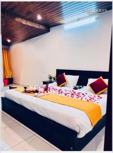 1 dormitorio con 1 cama grande con sábanas rojas y amarillas en MALLIKAYIL Recidency, en Vagamon