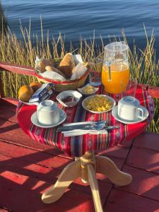 プーノにあるTiticaca uros floating lodgeの食べ物と飲み物を一皿用意したテーブル
