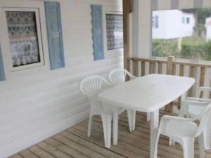 a white table and chairs on a porch at Mobil home confortable avec terrasse à Bretignolles-sur-Mer - API-1-52-656 in Brétignolles-sur-Mer