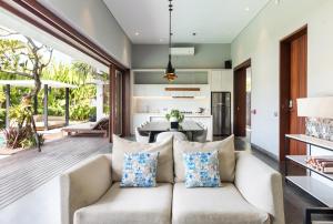an open living room with a couch and a kitchen at Amarin Seminyak in Seminyak