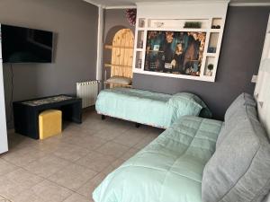 Una sala de estar con dos camas y un televisor. en Camping Los Cardones, en Gobernador Gregores