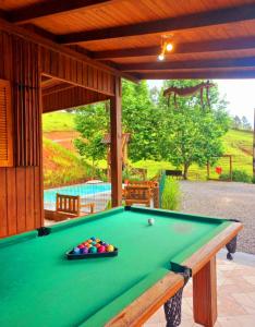 a green pool table in a pavilion with a pool ball at Recanto Paraíso da Colina in Santo Amaro da Imperatriz