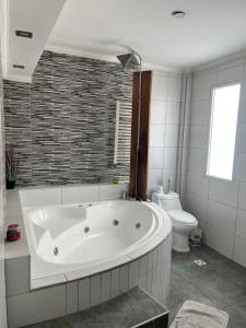 Un baño blanco con bañera y inodoro. en Camping Los Cardones, en Gobernador Gregores 16 fotos más