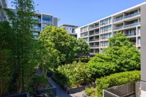 Un edificio de apartamentos con árboles en frente. en Rosebery Spacious 2Br Apt Near CBD Free Parking, en Sídney