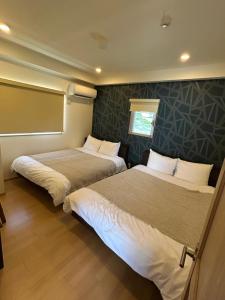 a bedroom with two beds and a chalkboard at Four Season Resort Kouri Island in Nakijin