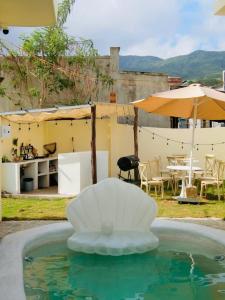 a fountain in a pool with a table and umbrella at Le Cosmos 2 Vĩnh Hy in Vĩnh Hy +44 photos