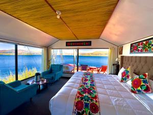 a bedroom with a large bed and a view of the water at Uros Qhantany Lodge in Puno +46 photos