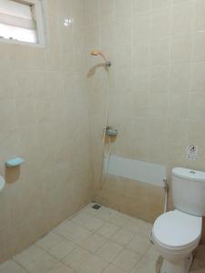 a bathroom with a toilet and a shower at Puri Kedaton Hotel-Residence-Meetings in Denpasar