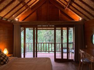 a bedroom with a bed and a large window at The Payung House in Bebandem