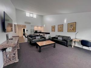 a large living room with couches and a table at Crown on Darby Newcastle in Newcastle