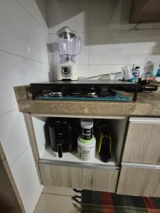 a kitchen cabinet with a stove and a counter top at Ed Gift Home Setor Oeste in Goiânia +6 photos