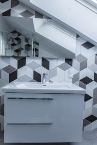a bathroom with a white sink and black and white tiles at Kandahar Lodge in Garmisch-Partenkirchen